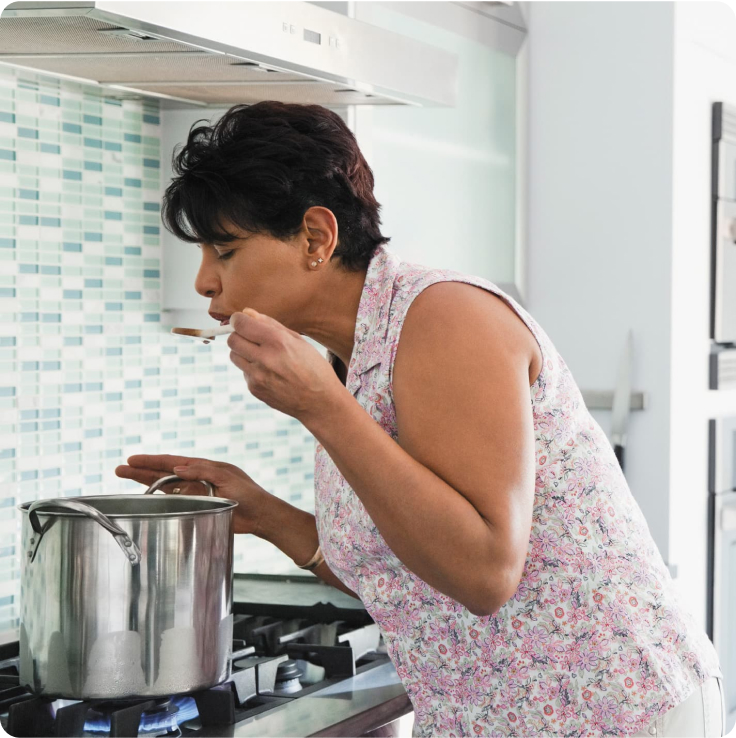 Woman tasting cooking soup